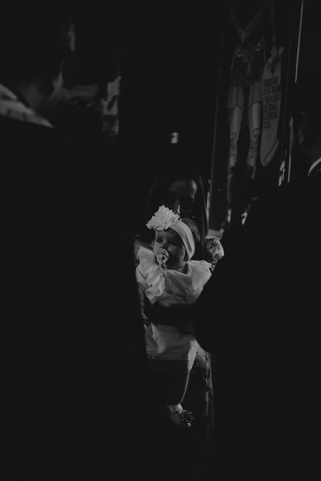 Bambino con fascia floreale bianca e ciuccio in stile donna