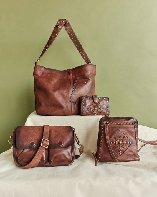 Elegant brown leather handbag with studded straps and turquoise inlay.