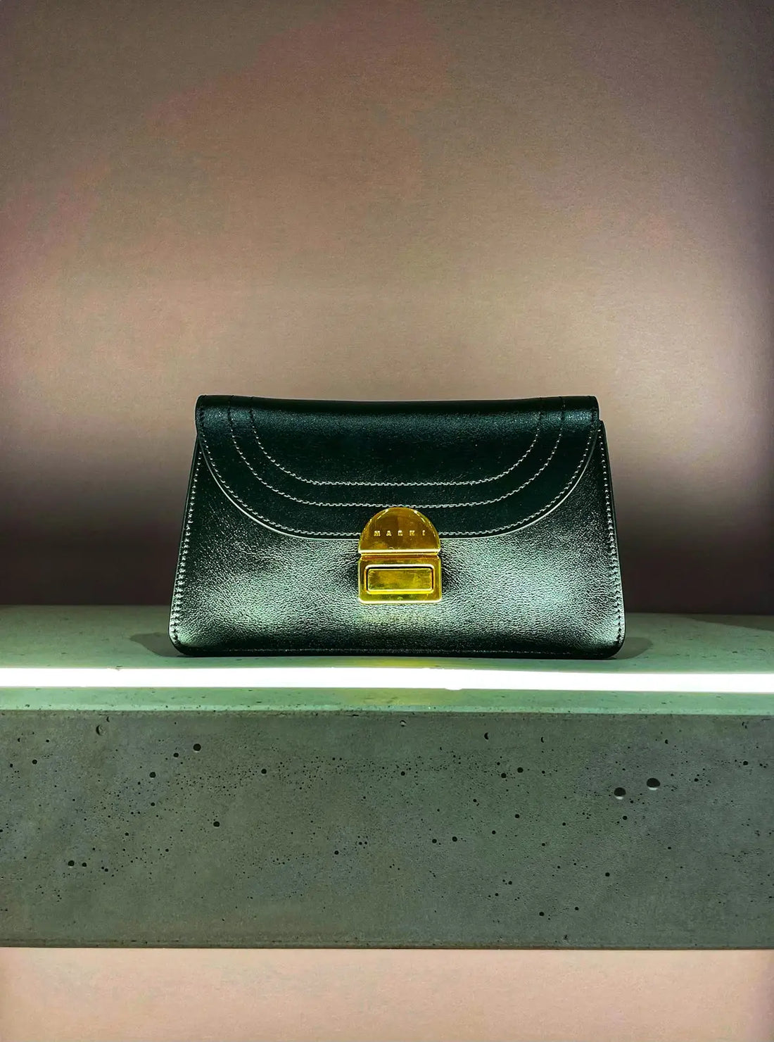 Borsa italiana in pelle nera con hardware dorato e chiusura a pattina curva