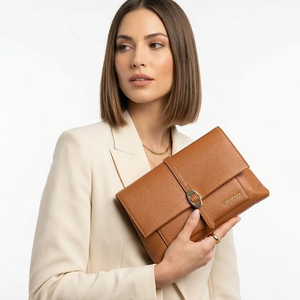 Clutch in pelle scamosciata beige con fibbia ovale tono argento e il nome del marchio 'conica' in rilievo sul lato.